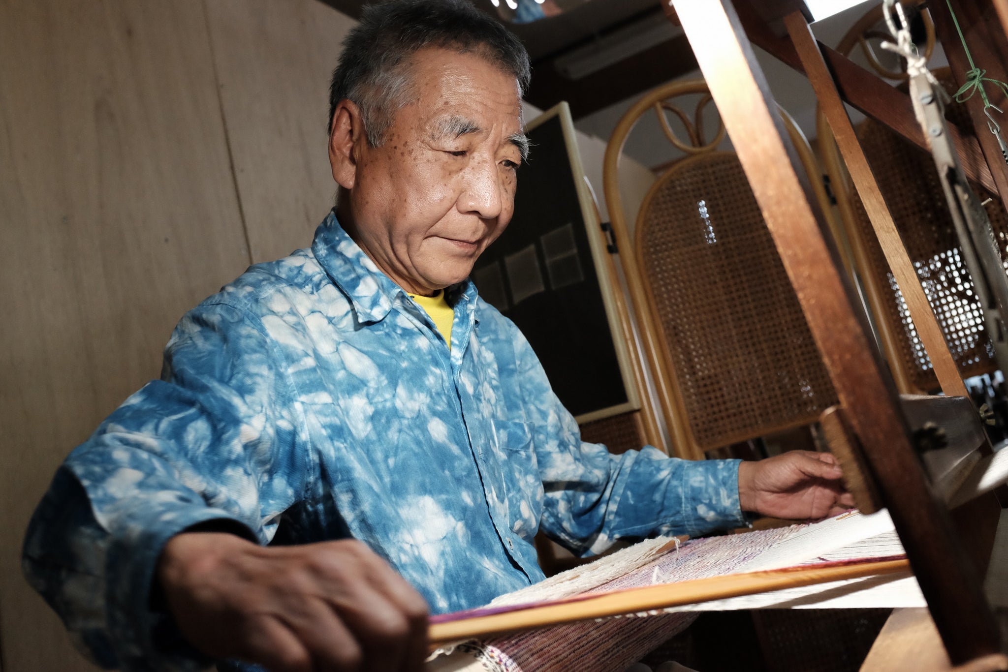 japanese man prepares a loom to weave jacquard silk